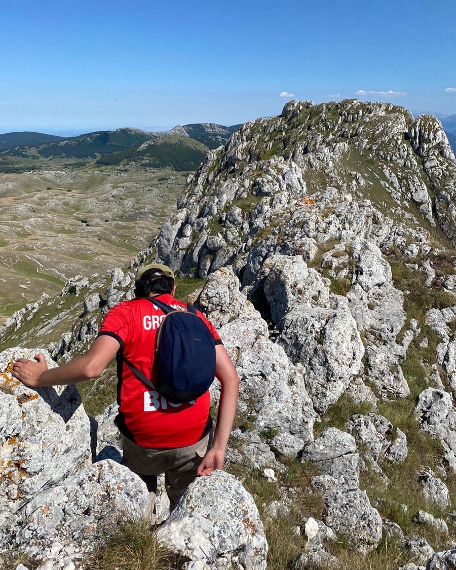 Hiking along a rocky mountain ridge under a clear blue sky